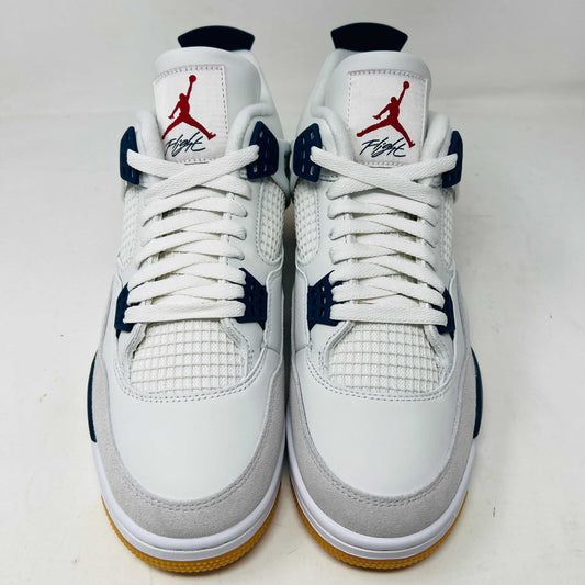 The Jordan 4 Retro SB Navy from Holy Ground Sneaker Shop, with white and navy mesh and orange details, sits on a pristine box showcasing the Nike SB logo. Its cushioned heel ensures its a perfect accessory addition.