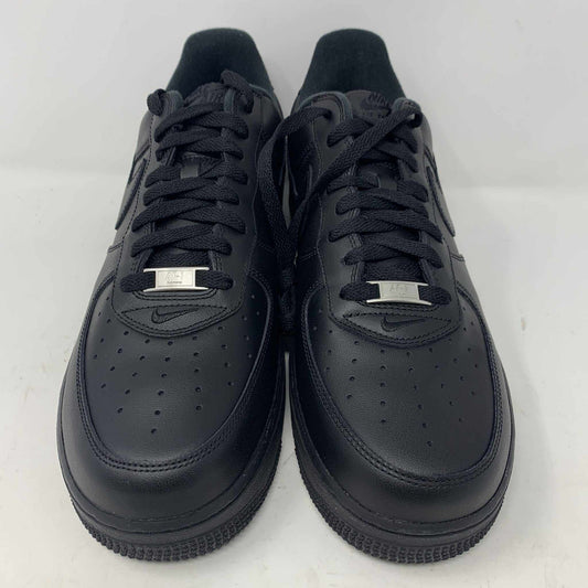 The Nike Supreme Air Force 1 Black features a perforated design on the toe box, black supreme laces with a shiny tag, and a prominent Nike logo, all set against a plain white background.