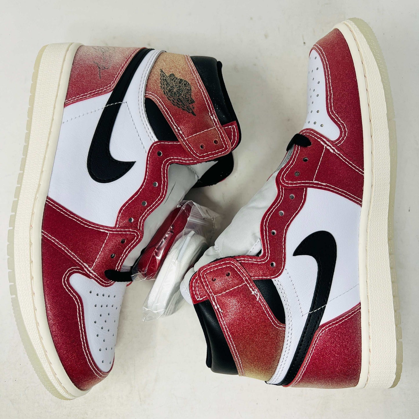Brand new Jordan 1 Retro High Trophy Room Chicago sneakers in red, white, and black on a blue Nike box. An invitation card from 2021 and a basketball-themed certificate in front highlight the authenticity of these iconic Jordan shoes.