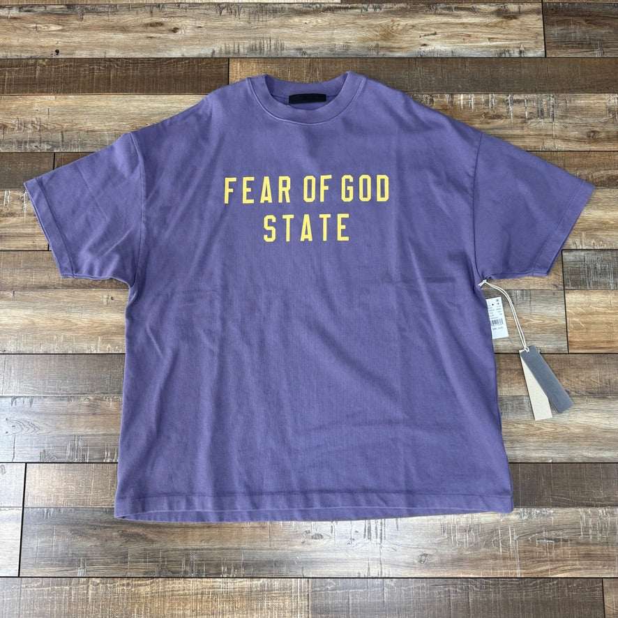Fear of God Essentials Heavy Crewneck Tee in Lavender on wooden floor.