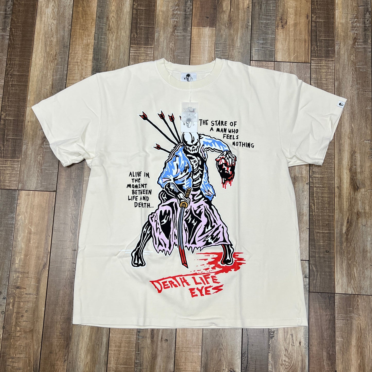 Warren Lotas Man Who Feels Nothing Tee Cream, brand new, featuring illustrated graphic and text.