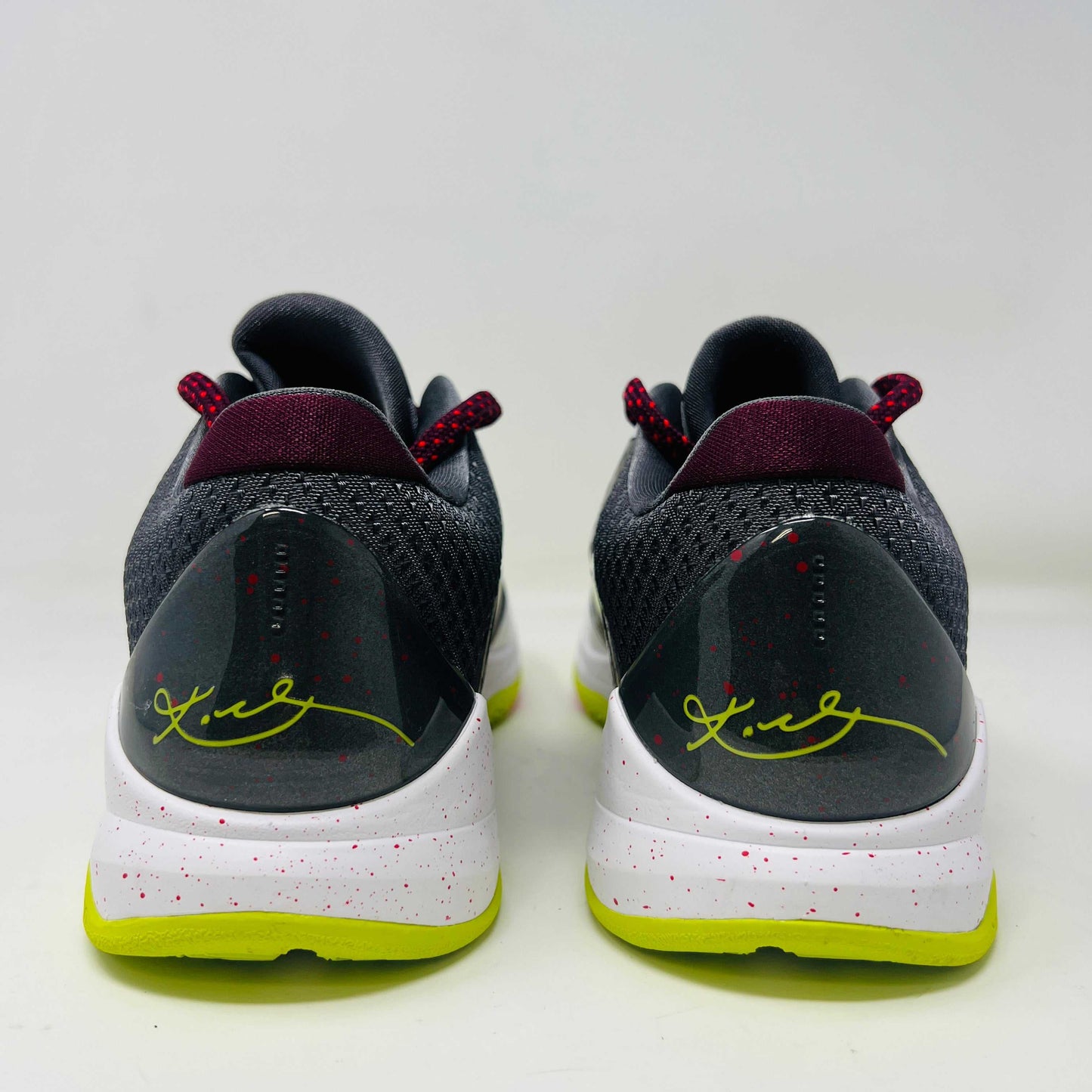 The Nike Kobe 5 Protro Chaos sneaker features a white and purple upper, neon yellow swoosh, maroon laces, and a neon yellow sole with red speckles. It is brand new in its sleek black box.