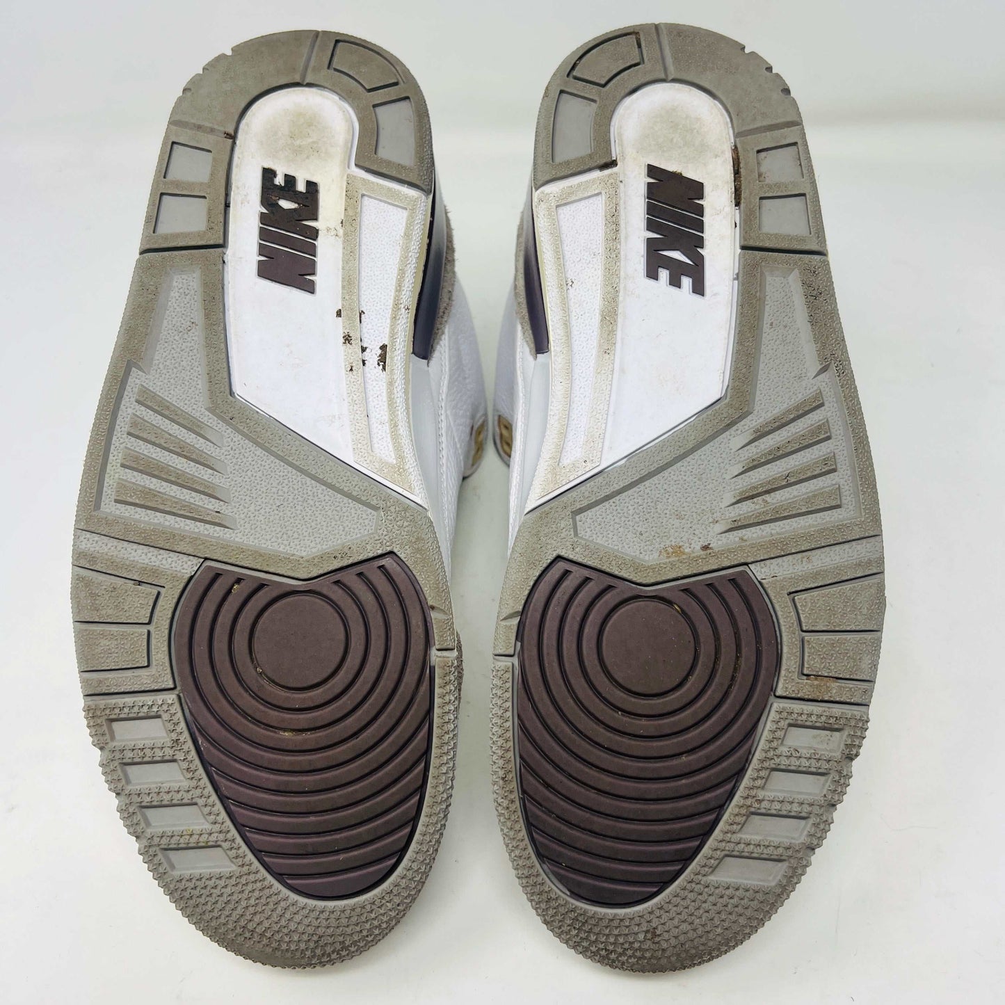 The Holy Ground Jordan 3 Retro SP A Ma Maniére (Womens) sneakers in white and gray, priced at $450, are displayed atop their box. They feature textured leather, suede accents, and include a pack of cream-colored extra laces for customization.