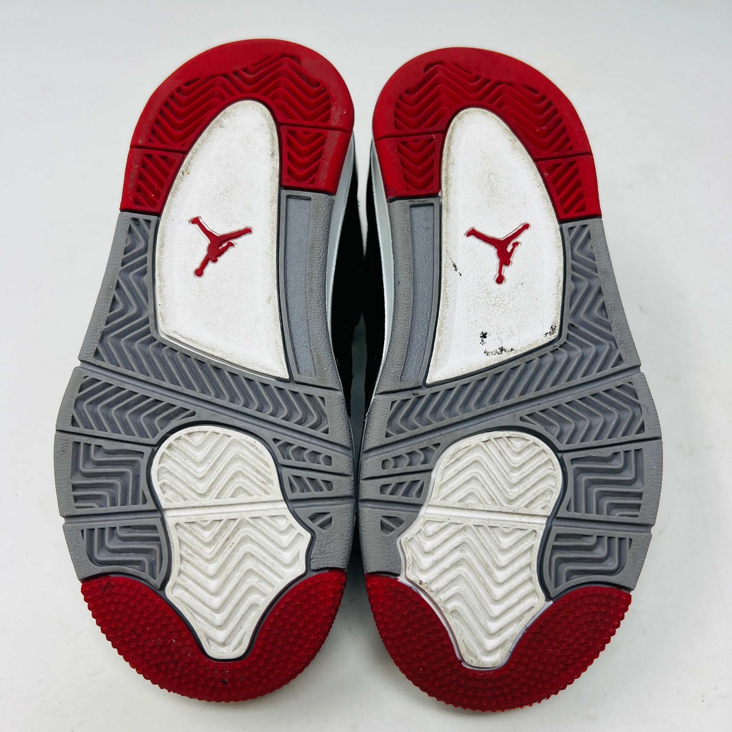 The Jordan 4 Retro Bred (2019) (PS) in black and red, featuring clean uppers with a white midsole and gray accents, sits on its original black shoebox. The box displays size, product details, and the iconic Jumpman logo, underscoring these authentic shoes from Jordans 2019 collection.