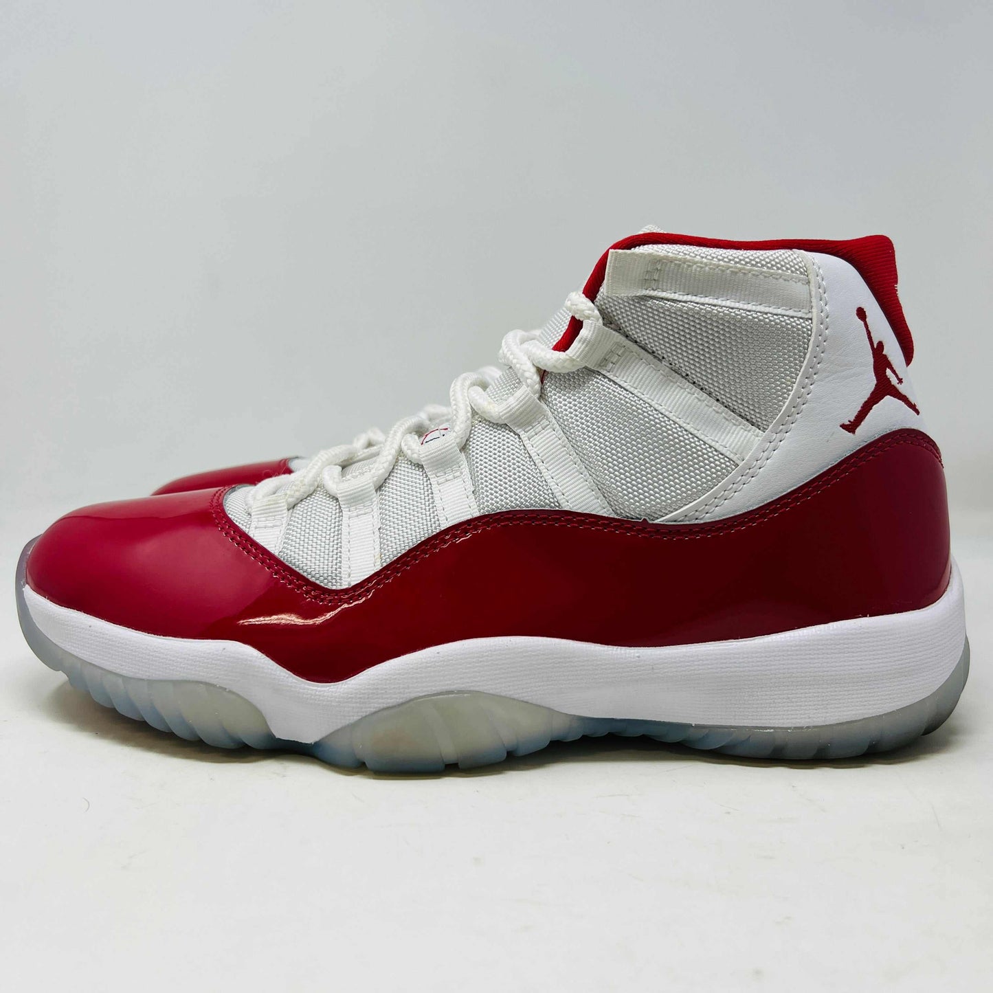 Jordan 11 Retro Cherry (2022) sneaker, red and white colorway, near-new condition, side view.