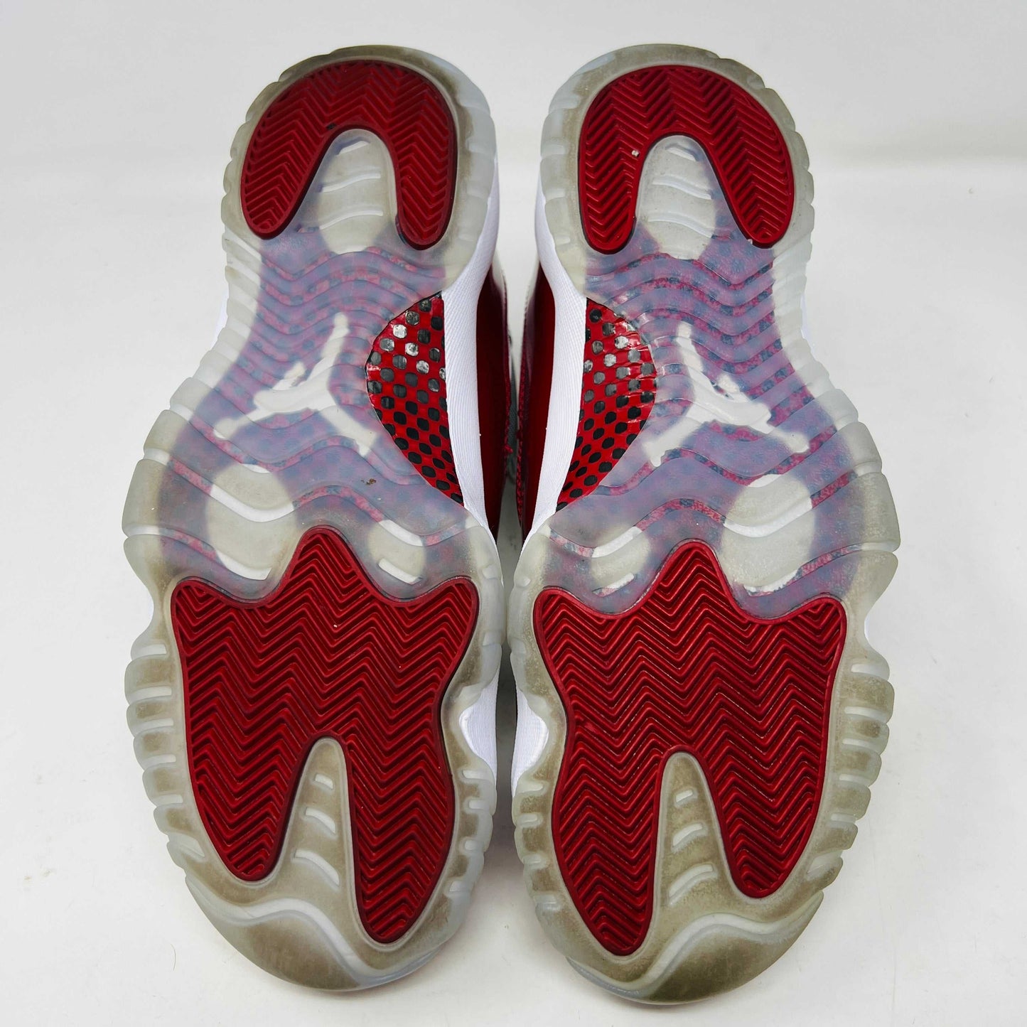 The Jordan 11 Retro Cherry (2022) is a red and white high-top sneaker with glossy red patent leather on the toe, clean mesh uppers, striking red accents, pristine white laces, a visible air sole unit, and the authentic Jumpman logo. Its in impeccable condition after being worn once.
