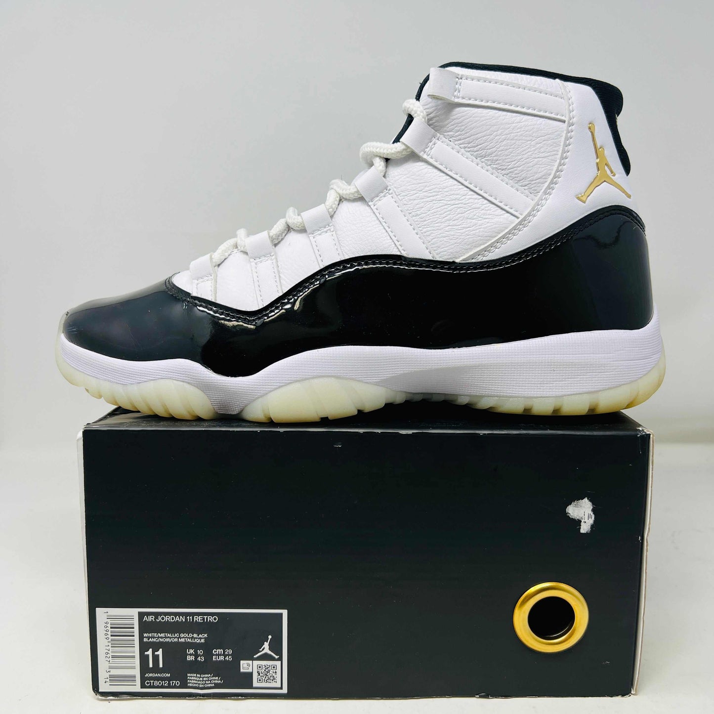 Jordan 11 Retro DMP Gratitude (2023) sneaker with clean uppers and light wear displayed on box.