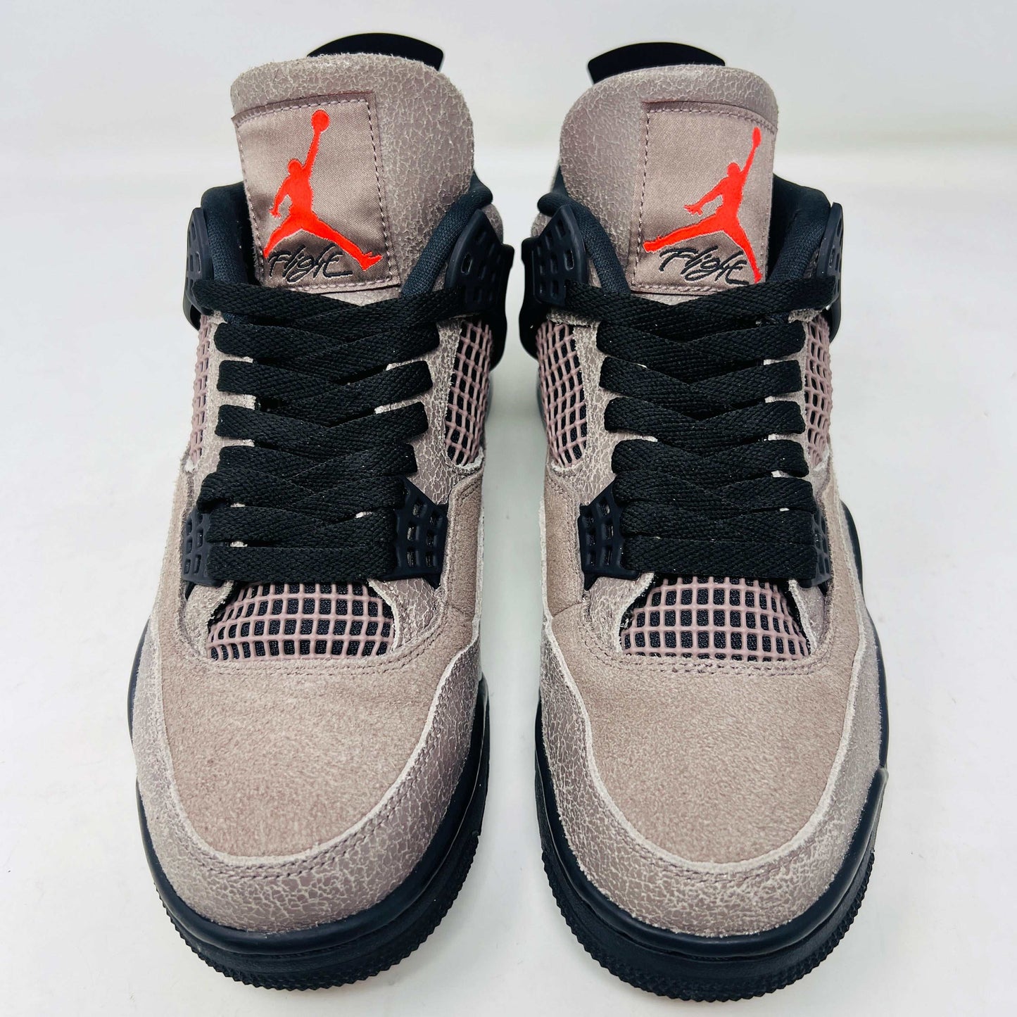 The Jordan 4 Retro Taupe Haze sneaker is showcased on its speckled brown shoebox. Released in 2021, it boasts black mesh accents, a visible air unit, and the Jumpman logo on the tongue. Size and style details are printed on the box.