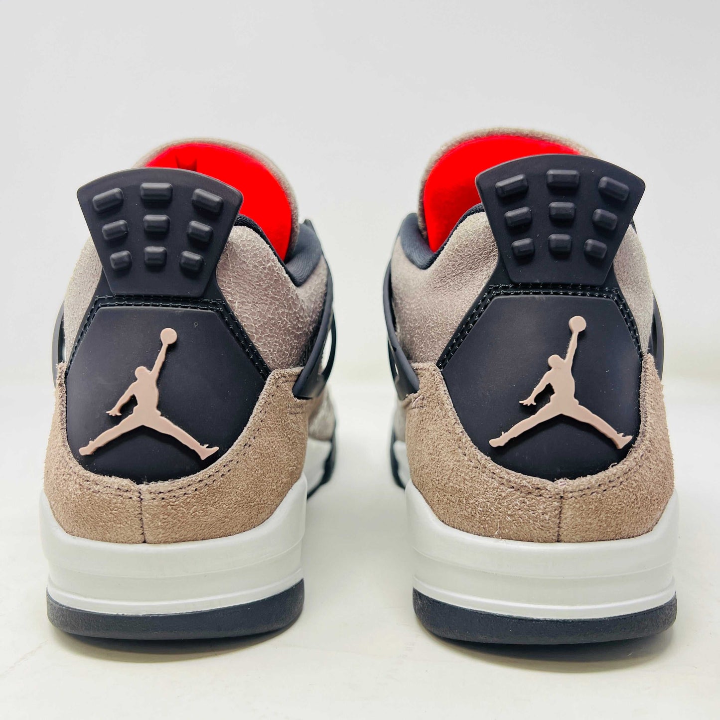 The Jordan 4 Retro Taupe Haze sneaker is showcased on its speckled brown shoebox. Released in 2021, it boasts black mesh accents, a visible air unit, and the Jumpman logo on the tongue. Size and style details are printed on the box.