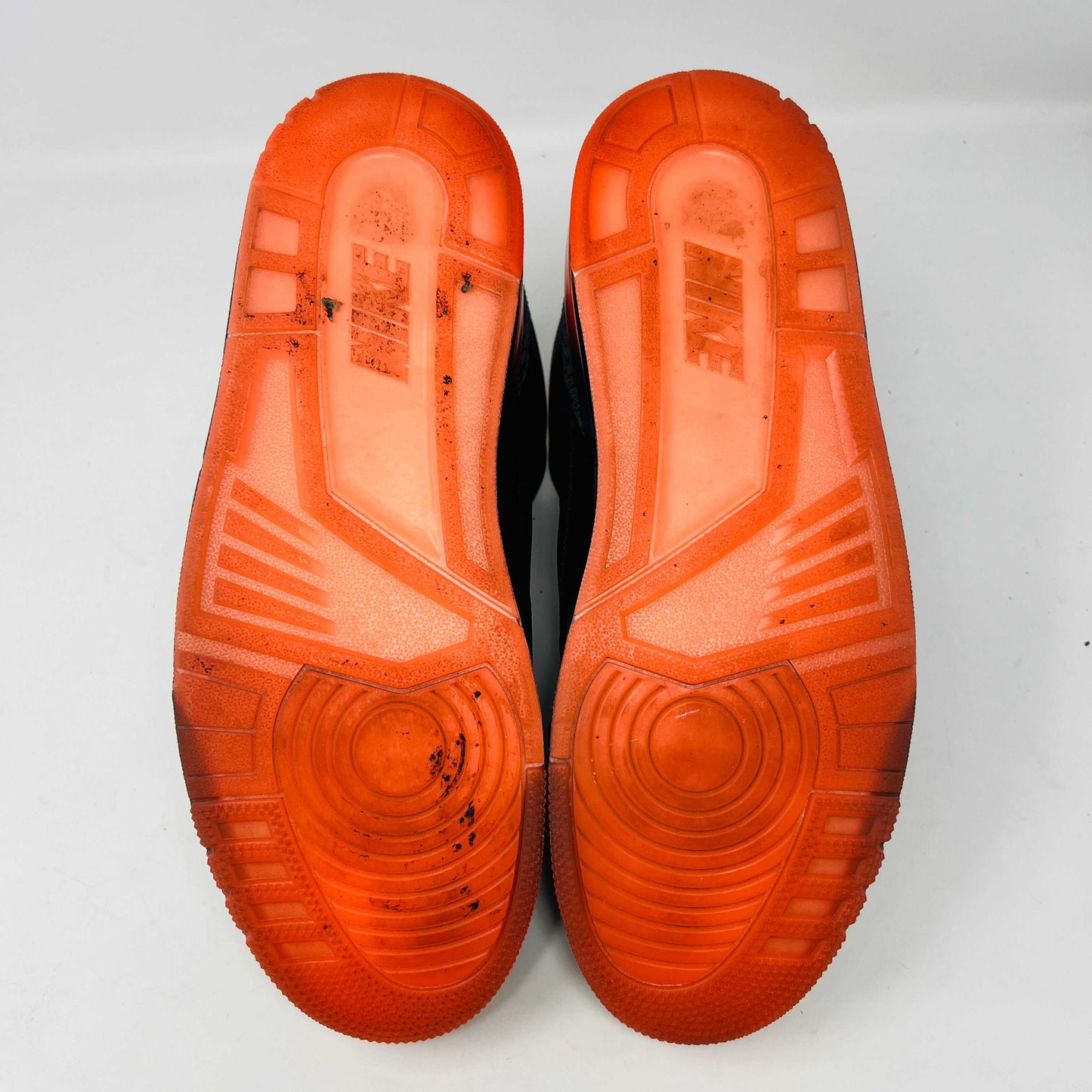 The Jordan 3 Retro J Balvin Rio sneaker in black features clean uppers and textured details with a vibrant gradient heel. It comes atop a box with a black and orange sunset design, accompanied by bright orange laces, ensuring authenticity.
