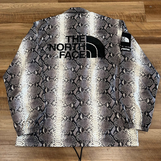 Supreme The North Face Snakeskin Taped Seam Coaches Jacket in black snakeskin pattern.