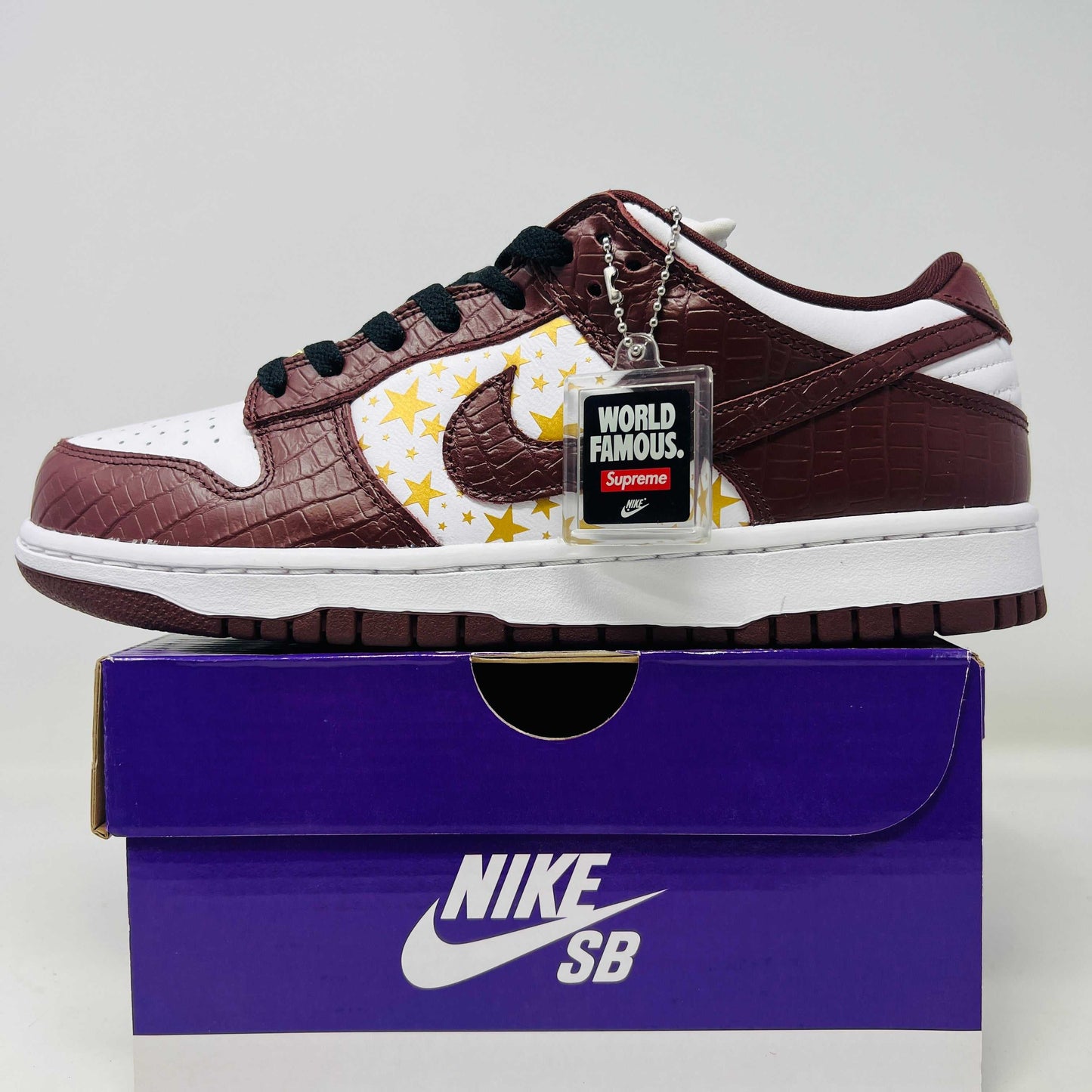 Nike SB Dunk Low Supreme Barkroot sneakers in brand new condition on a purple box.