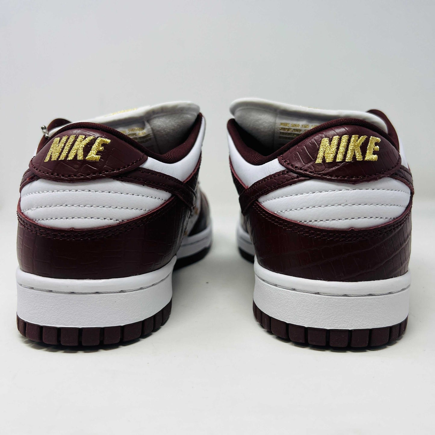 Introducing the new Nike SB Dunk Low Supreme Barkroot sneakers by Nike, featuring a star pattern with a World Famous Supreme tag and housed in a striking purple Nike SB box.