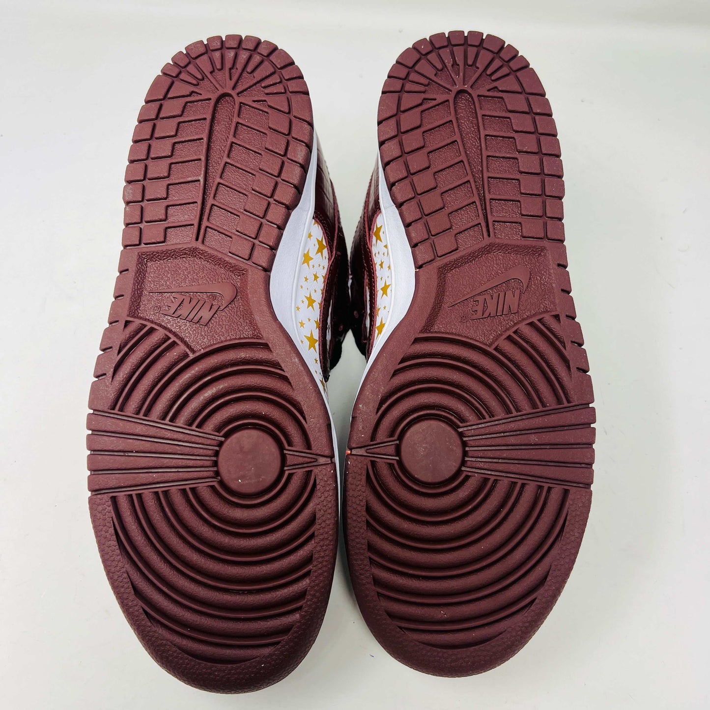 Introducing the new Nike SB Dunk Low Supreme Barkroot sneakers by Nike, featuring a star pattern with a World Famous Supreme tag and housed in a striking purple Nike SB box.