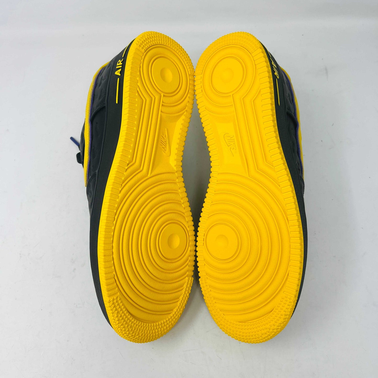 Brand new Nike Air Force 1 Low Kobe Bryant Lakers Away sneaker in black with yellow and blue accents, featuring embossed details. Displayed on a white box with a yellow Nike logo and Kobe Bryant symbol. Limited edition of 8000, ideal for those seeking standout accessories.