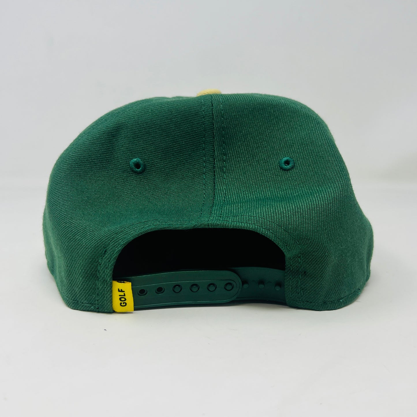 The Golf Wang New Era Camp Flog Gnaw 2018 Snap Back by Holy Ground Sneaker Shop features a green crown, yellow brim, and bold white/yellow G on the front. The brim sticker says 19 TWENTY and ADJUSTABLE.