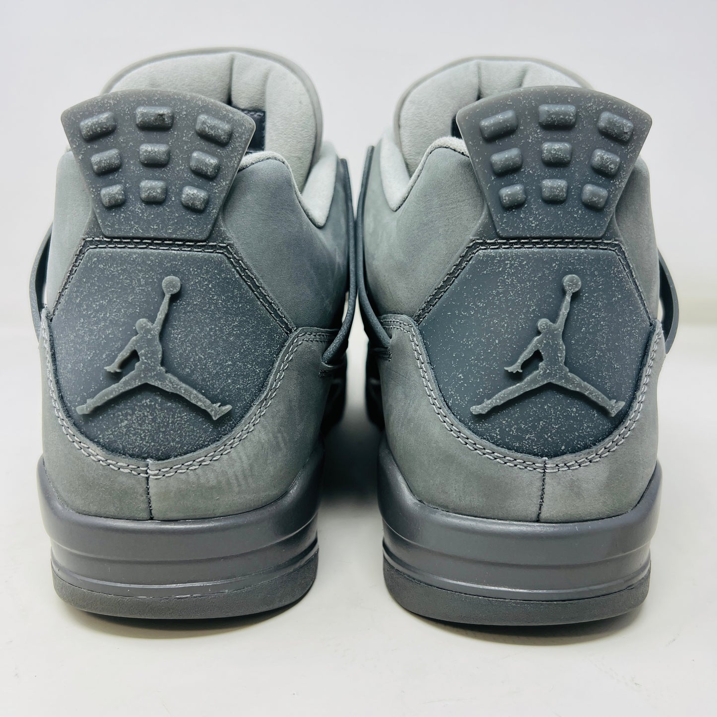The Jordan 4 Retro SE Paris Olympics Wet Cement sneaker is displayed on its matching gray textured box, showcasing both in pristine condition. It features clean uppers with smooth and mesh textures, a visible air unit, and a size label with US, UK, and EU measurements.