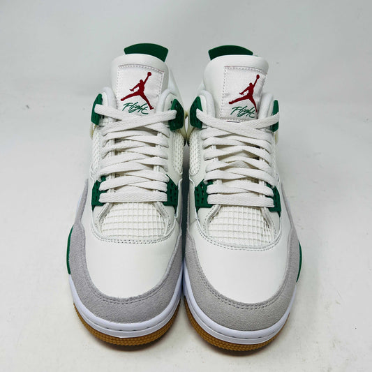The Jordan 4 SB Pine Green sneakers feature a white and green design with red logo accents, gum-colored soles, and showcase mesh and suede details from the front.