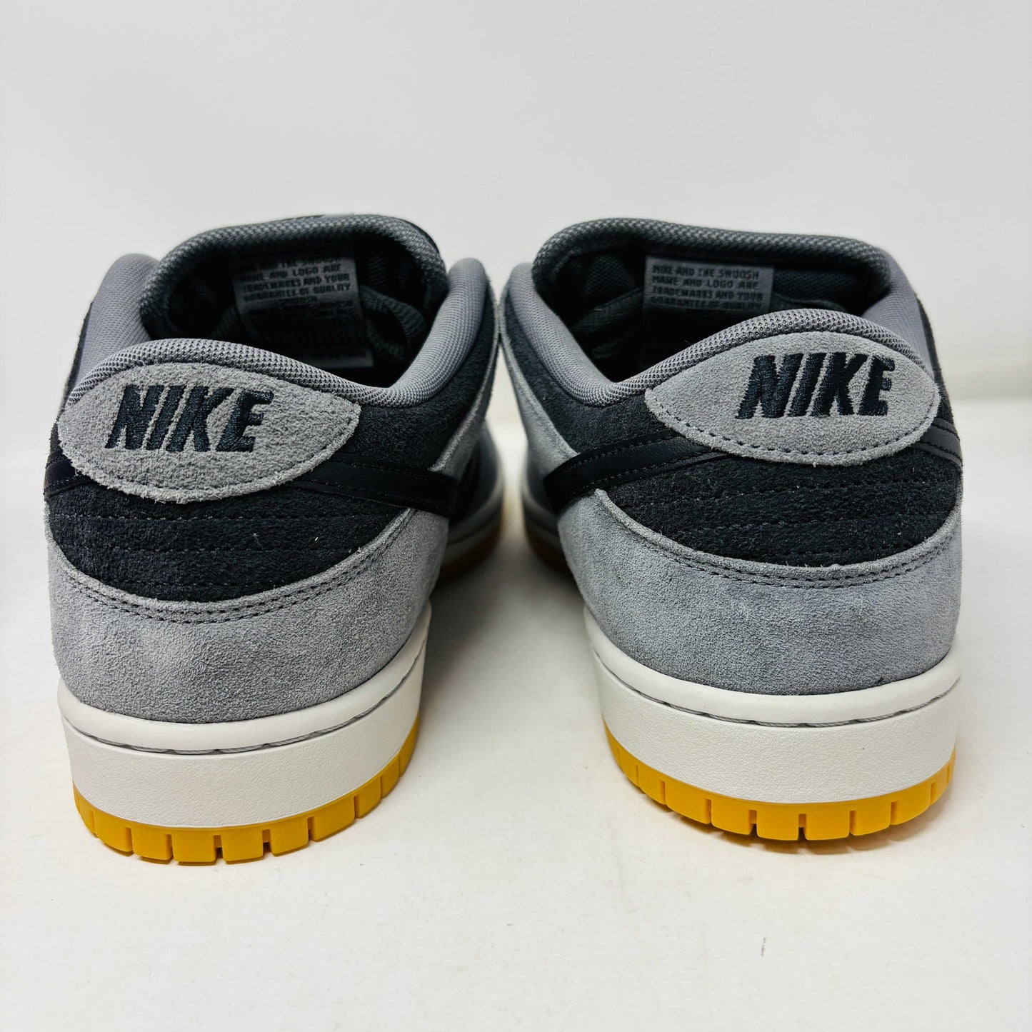 Introducing the Nike SB Dunk Low Dark Smoke Grey sneakers, featuring a gray and black design with a mustard sole. Packaged in a signature purple box with extra black laces, these 100% authentic sneakers ensure your style stays fresh and versatile.