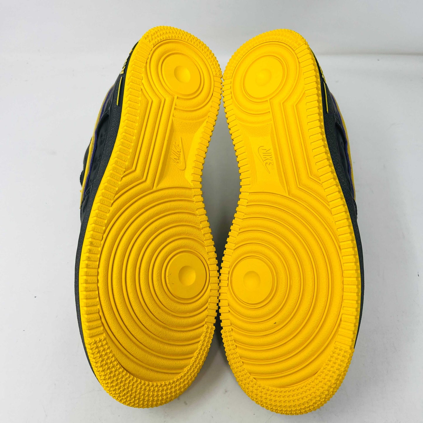 The new black Nike Air Force 1 Low Kobe Bryant Lakers Away sneakers have yellow accents like a swoosh and sole, sitting on a white box with the Nike logo and icon. These 100% authentic shoes are available as a final sale item.