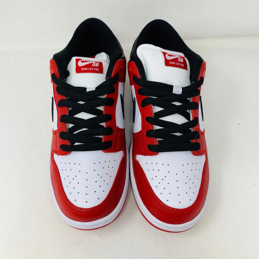 A brand new Nike SB Dunk Low J-Pack Chicago sneaker in red, white, and black sits on a purple Nike SB box with extra white laces, highlighted by a black swoosh and guaranteed 100% authentic.