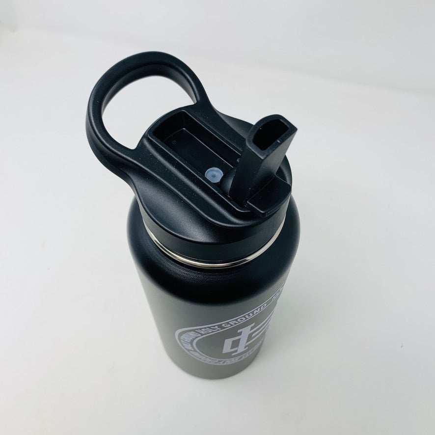 Holy Ground Water Bottle with black handle and flip-top lid.
