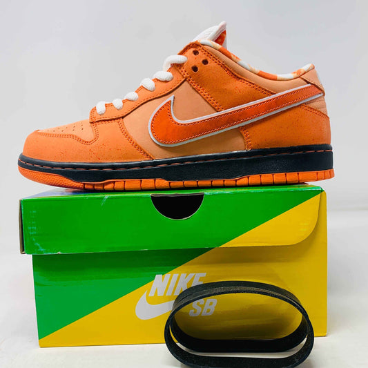 Nike SB Dunk Low Orange Lobster Concepts sneakers, brand new with extra laces and black bands, on a colorful box.