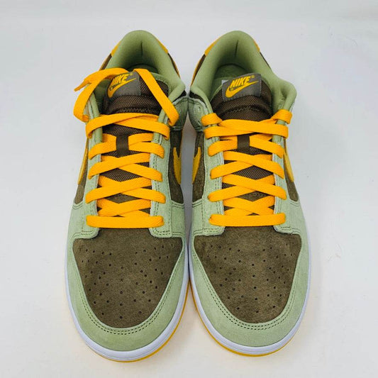 Nike Dunk Low Dusty Olive sneakers with yellow laces.