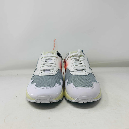 The Nike Air Max 1 Patta Waves White, a brand new sneaker, features a visible air cushion sole and swoosh logo. It comes elegantly displayed on a matching P.G.L.F.A. box with extra laces in a plastic bag attached to the tongue.