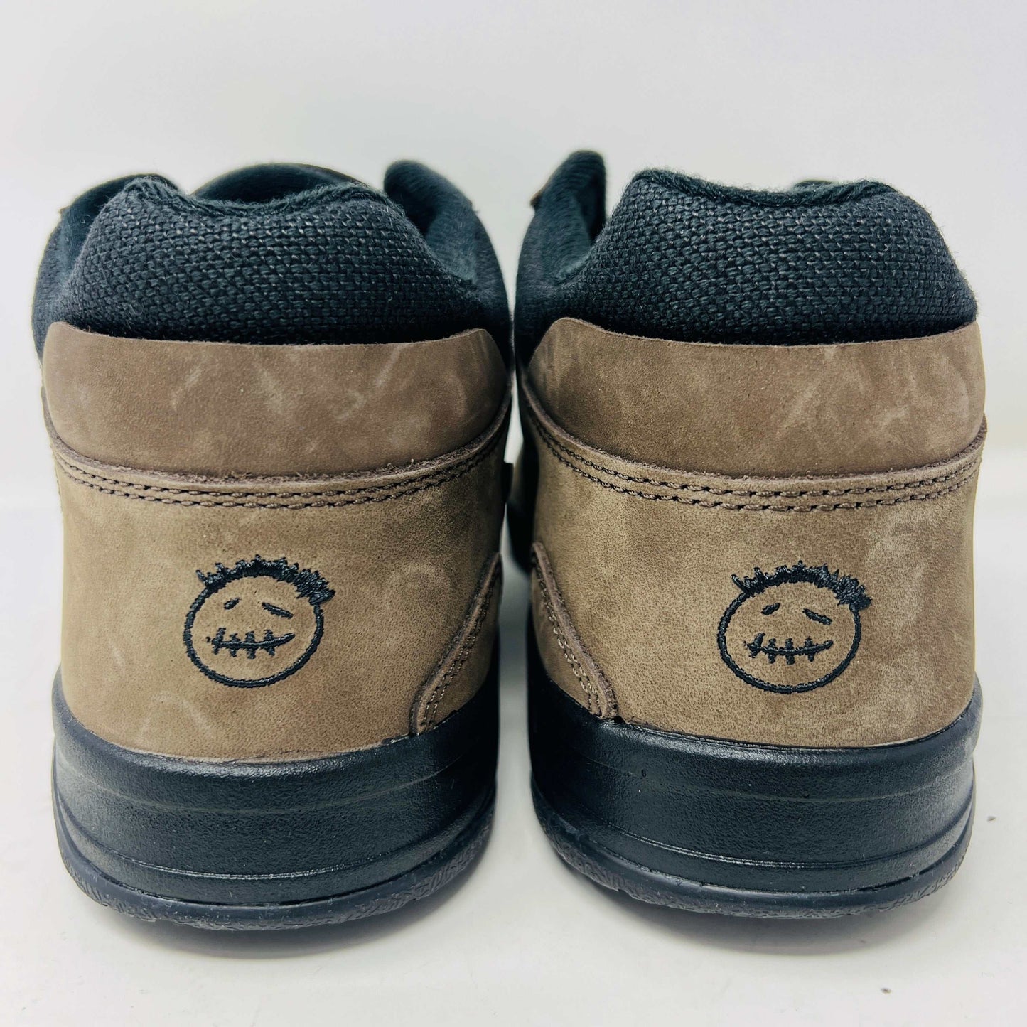 A pair of Jordan Jumpman Jack TR Travis Scott Dark Mocha sneakers are showcased on a brown box labeled JACK in white. The brown and black sneaker features a black swoosh, laces, and textured sole. Its 100% authentic with extra laces and bag, set against a plain white background.