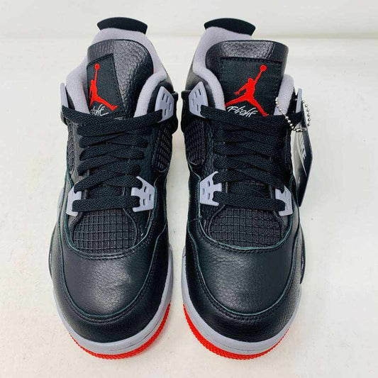 Jordan 4 Retro Bred Reimagined GS sneakers in black and red with Jumpman logo on tongue and heel.