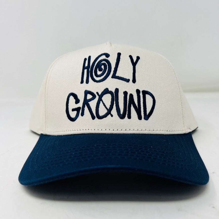 The Holy Ground Stussy Hat by Holy Ground is a streetwear accessory with HOLY GROUND embroidered in black on its white front panel, complemented by a green bill for a fresh touch.