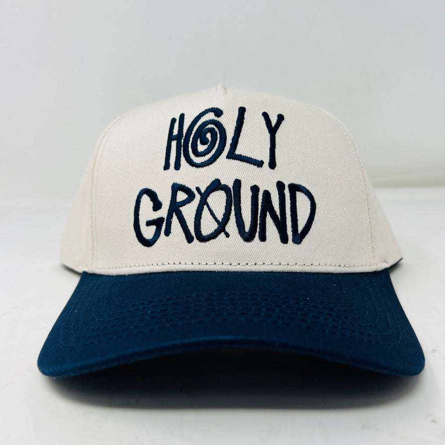 The Holy Ground Stussy Hat by Holy Ground is a streetwear accessory with HOLY GROUND embroidered in black on its white front panel, complemented by a green bill for a fresh touch.