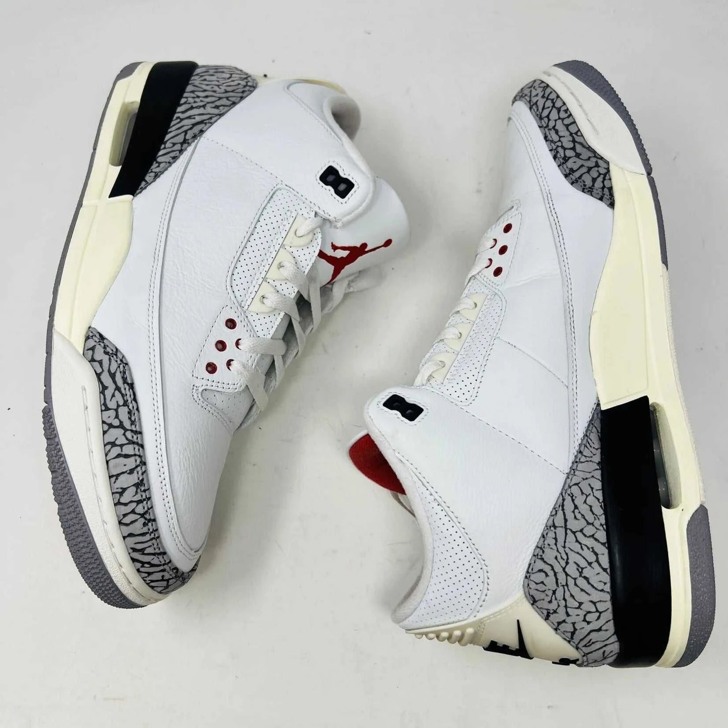 The Jordan 3 Retro White Cement Reimagined sneaker, size 13, features authentic quality with elephant print accents, black and red details, and a visible air unit. It comes in a matching Nike Air shoebox highlighting branding details.