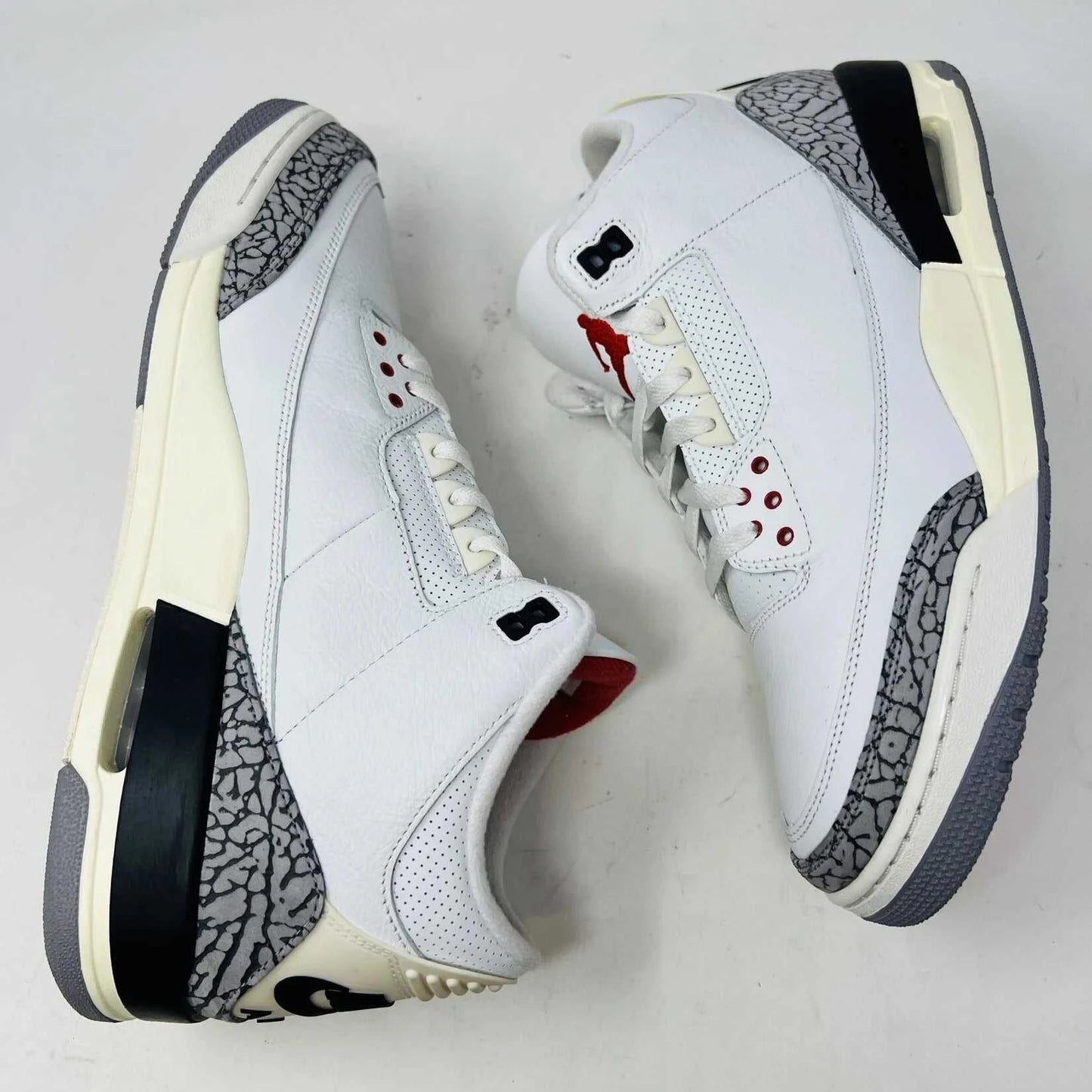 The Jordan 3 Retro White Cement Reimagined sneaker, size 13, features authentic quality with elephant print accents, black and red details, and a visible air unit. It comes in a matching Nike Air shoebox highlighting branding details.