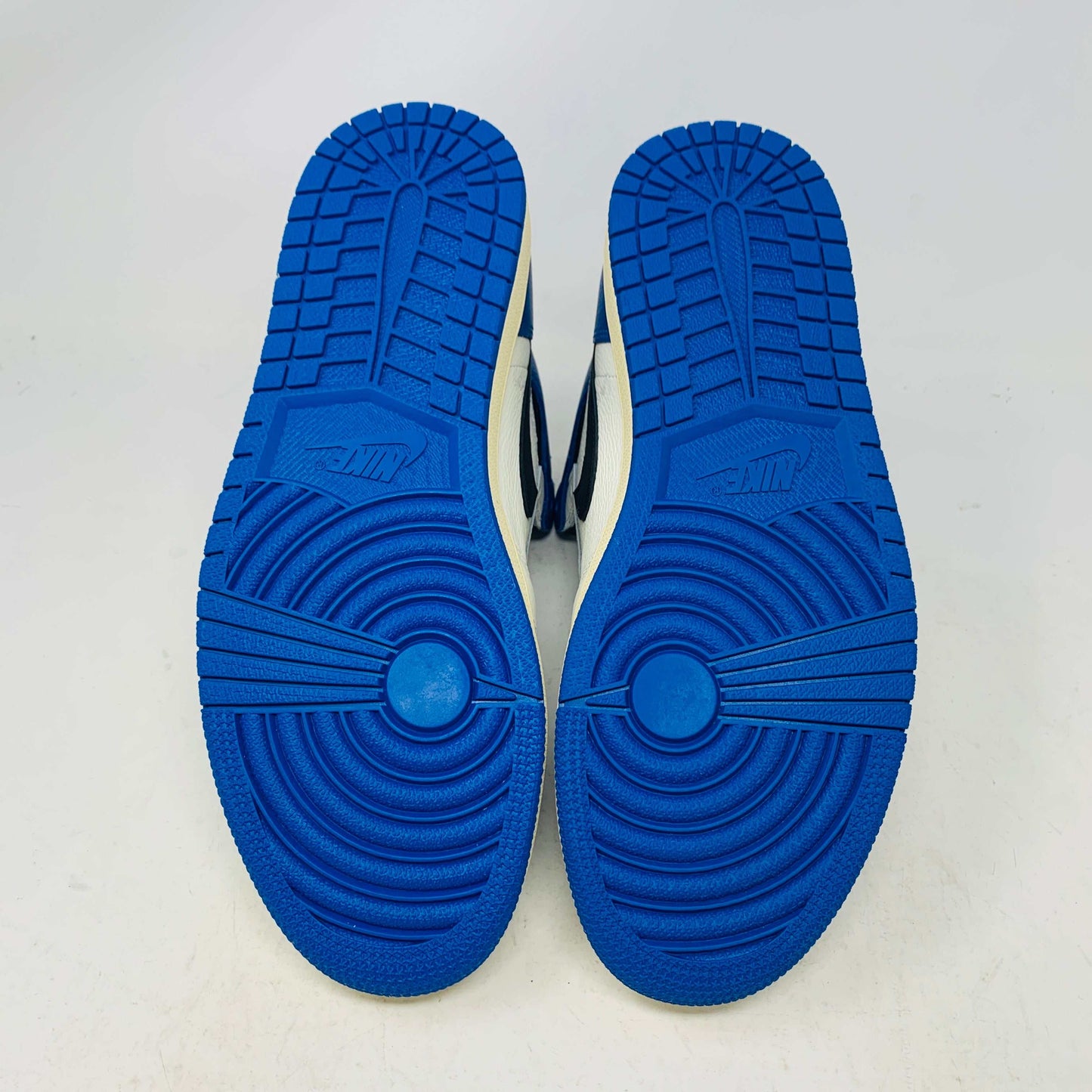 The Jordan 1 Retro High OG SP Fragment x Travis Scott is a new high-top sneaker featuring a blue, white, and black design with a unique backward Nike swoosh. It comes in a transparent, branded box adorned with butterfly and text details, boasting a thick sole and classic 1985 Air Jordan design.