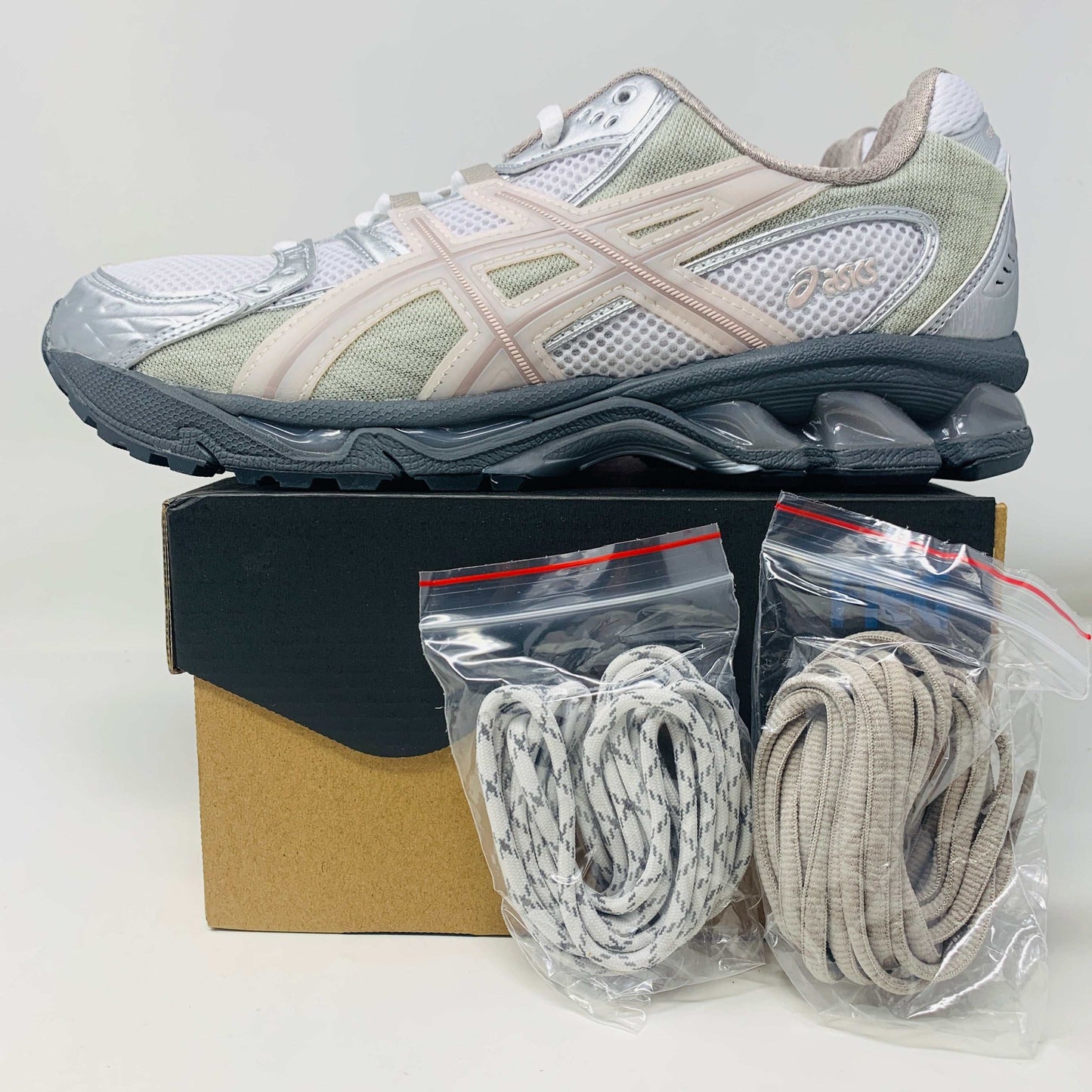 Brand-new ASICS Gel-Nimbus 10.1 Kith White Morganite sneakers, featuring silver and white mesh fabric with beige accents, viewed from above and placed side by side on a plain white background.
