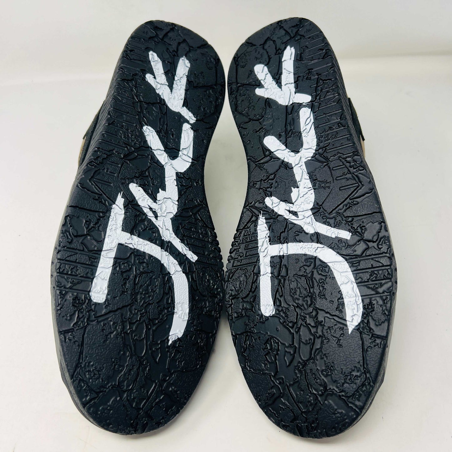A pair of Jordan Jumpman Jack TR Travis Scott Dark Mocha sneakers are showcased on a brown box labeled JACK in white. The brown and black sneaker features a black swoosh, laces, and textured sole. Its 100% authentic with extra laces and bag, set against a plain white background.