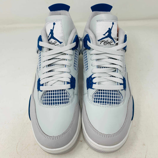 The Jordan 4 Retro Military Blue (2024) sneaker, with white and blue mesh details and a visible air cushion, rests on a black speckled NIKE AIR box with bold orange text. It is 100% authentic, including orange tags, ensuring it’s brand new.