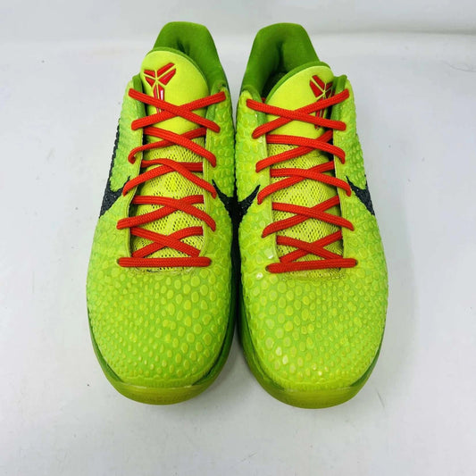 The Nike Kobe 6 Protro Grinch (2020) sports shoes are bright green with a textured surface, red laces, and feature the iconic black Nike swoosh logo. Zoom Air technology is indicated on their side. They are presented against a plain background.