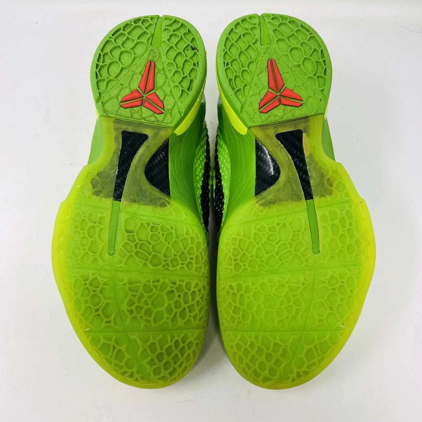 The Nike Kobe 6 Protro Grinch (2020) sports shoes are bright green with a textured surface, red laces, and feature the iconic black Nike swoosh logo. Zoom Air technology is indicated on their side. They are presented against a plain background.