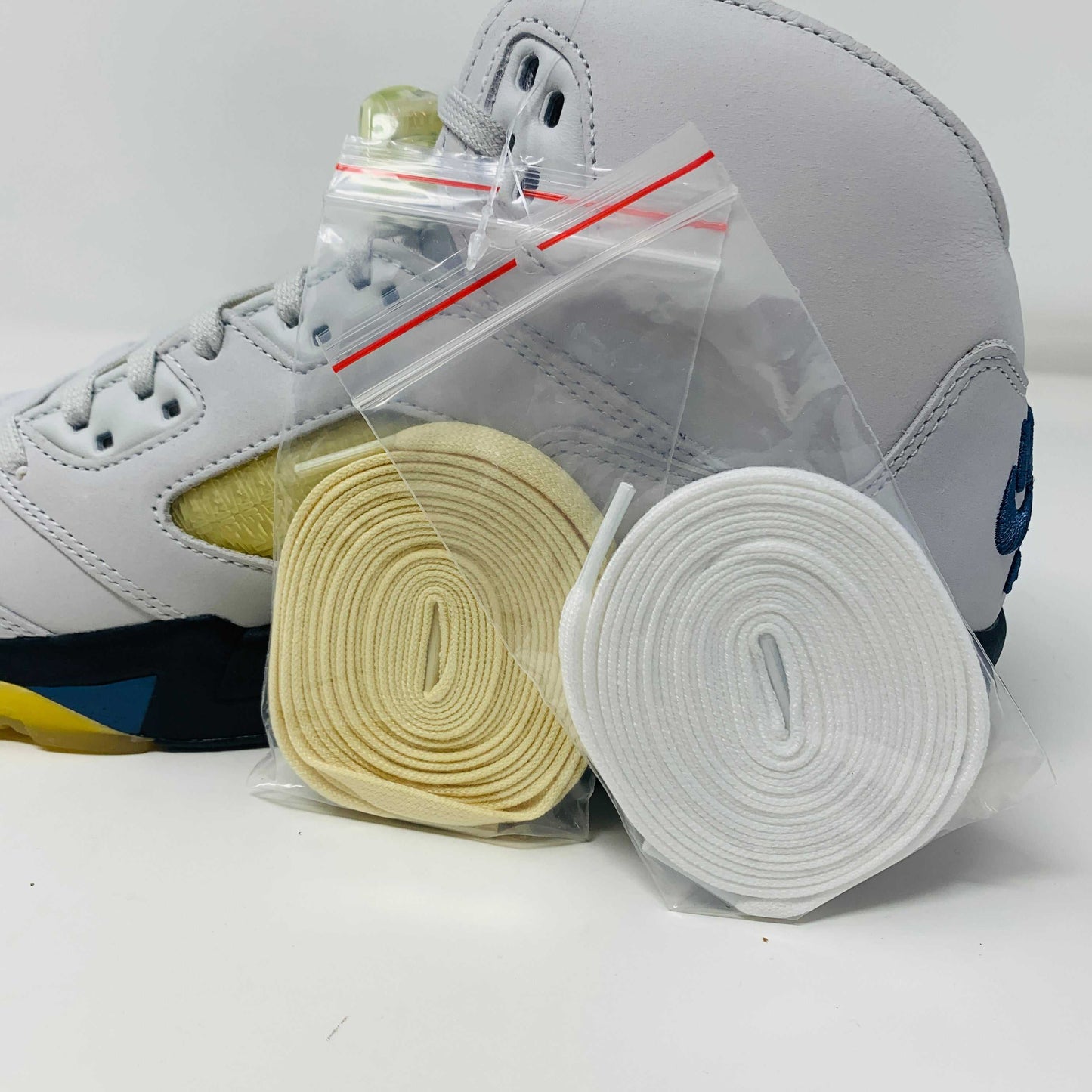 Jordan 5 Retro A Ma Maniére Dawn Women's sneaker with white, black, and gold design featuring iconic Jordan logo.