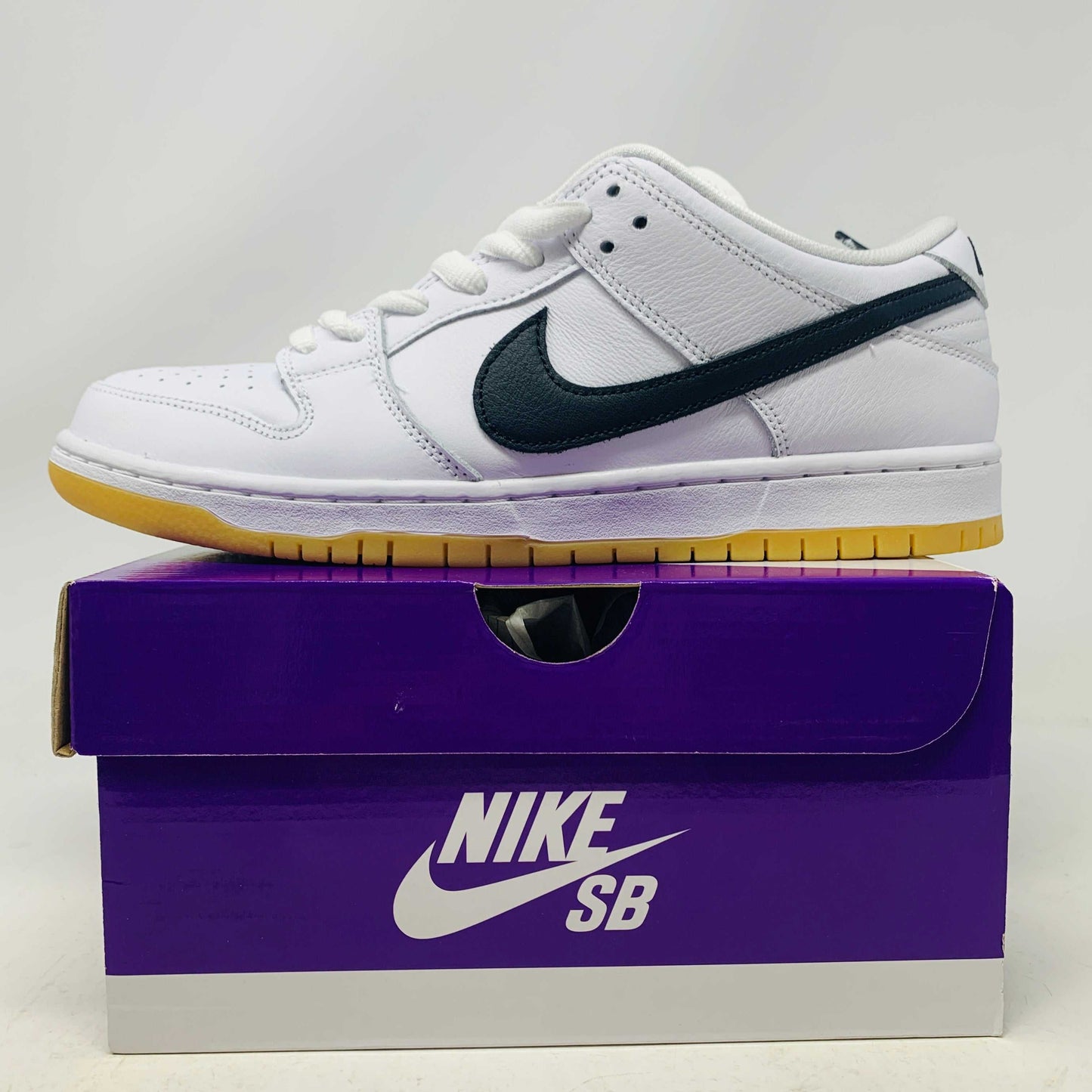 Nike SB Dunk Low White Gum sneakers in new condition, 2023 release, displayed on purple Nike SB box.