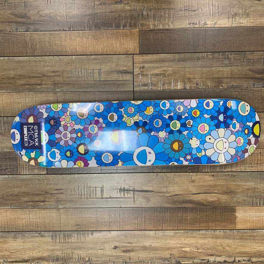 Takashi Murakami Flower Skateboard Deck Blue on wooden floor.