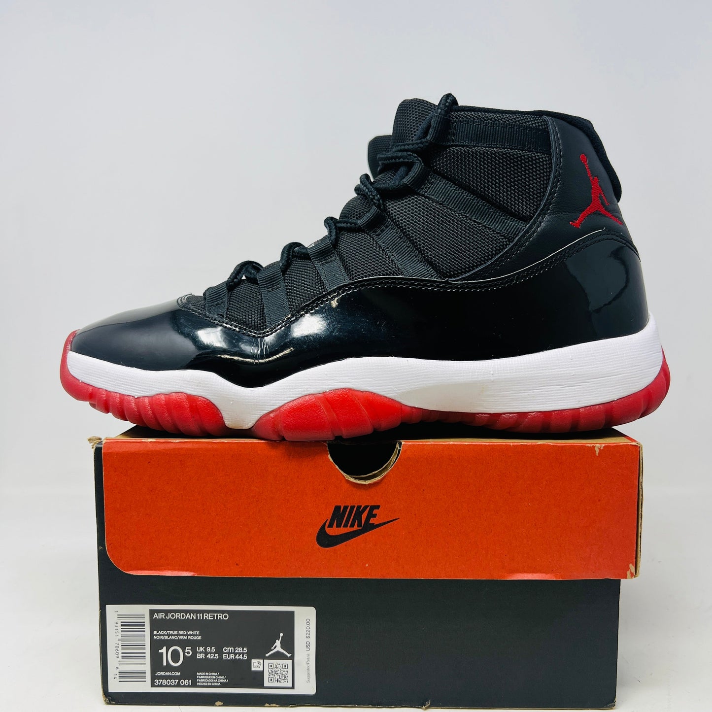 Jordan 11 Retro Playoffs Bred sneakers, condition 8.5/10, displayed on a box.