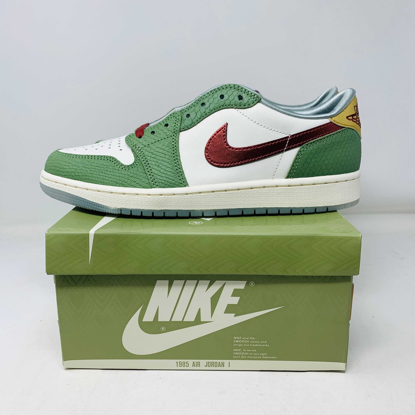 Jordan 1 Low Year Of The Dragon 2024 sneakers, brand new, green and white with red accents, on a Nike box.