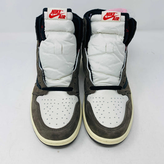 A pair of authentic Jordan 1 High Travis Scott Mocha sneakers in brown, white, and black is displayed on an orange and brown Nike shoebox. These feature a distinctive reversed black Swoosh and come with extra laces for versatile styling.