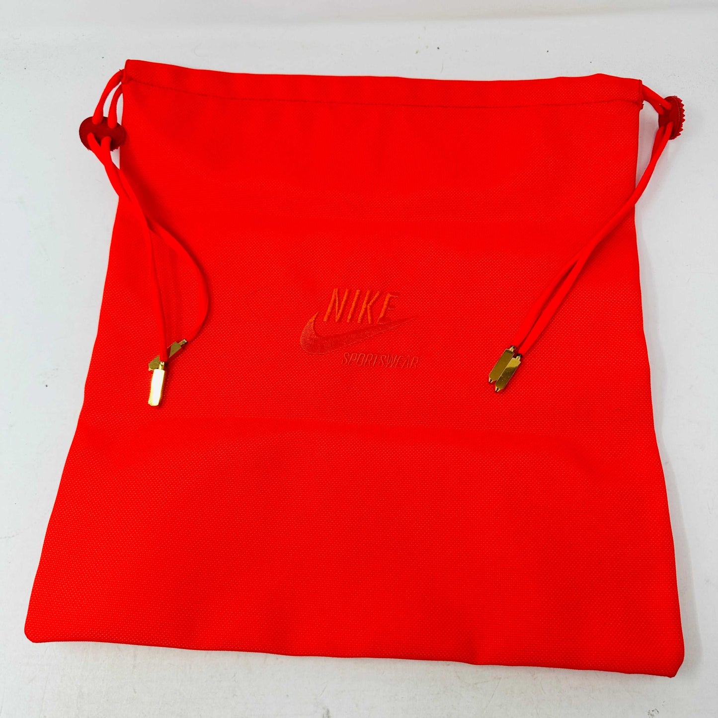 A pair of Nike Air Yeezy 2 Red October high-top sneakers, 100% authentic and brand new, features laces, a midfoot strap, and textured side detailing. Seen from the front against a white background, these bright red shoes showcase their unique style.