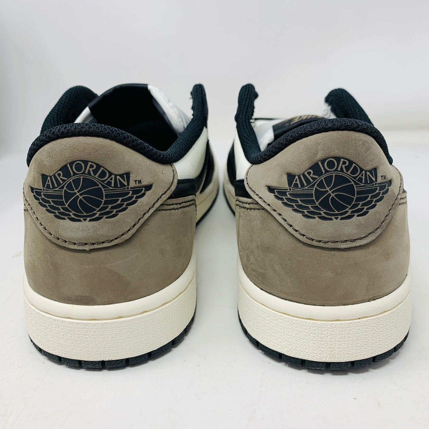 A pair of brand new Jordan 1 Retro Low OG Mocha sneakers has a brown suede heel with the Air Jordan logo in black, crafted in 2024. They feature white midsoles, black outsoles, and a stylish black and white interior. The box condition is good for quality delivery.