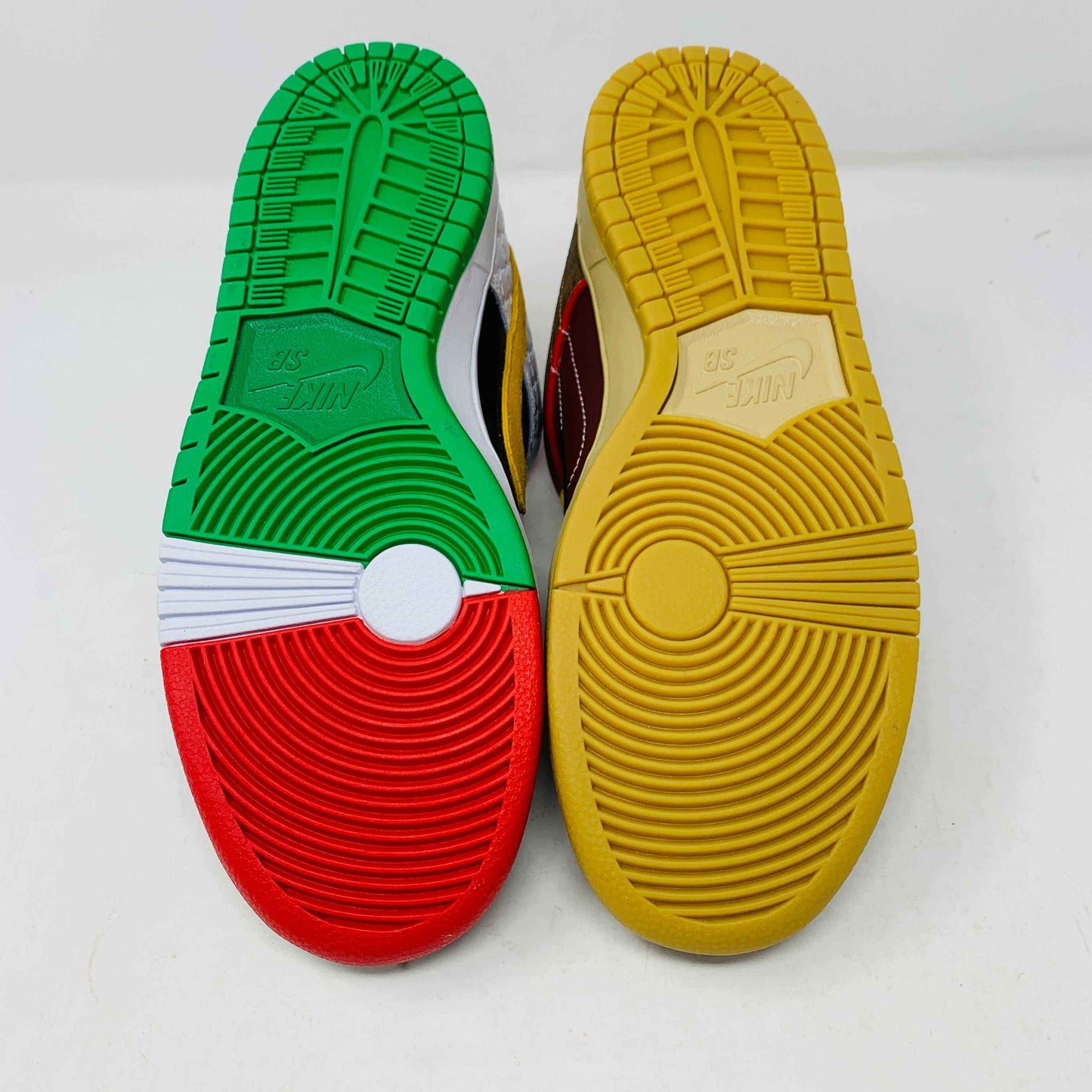 The Nike SB Dunk Low What the Paul is a 2021 authentic sneaker featuring varied textures and patterns like elephant print, a gradient swoosh, red laces, and comes in a colorful green, yellow, and white Nike SB box.